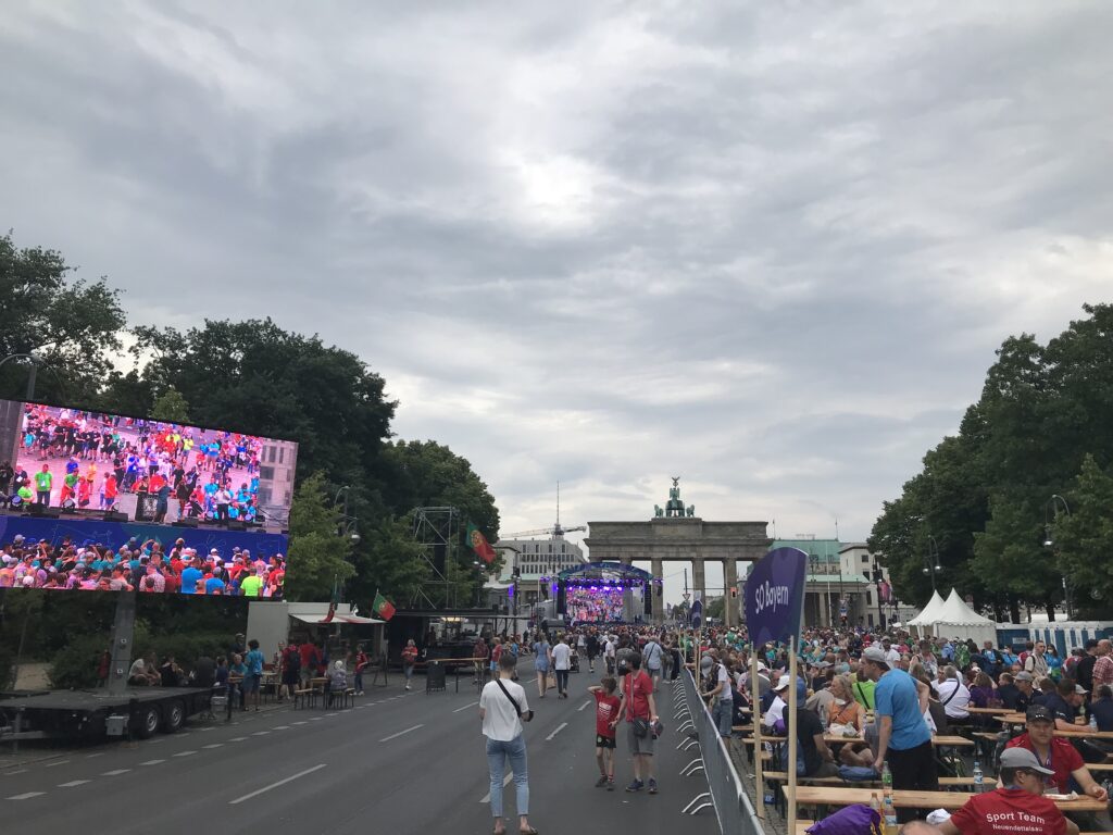 Supa Star Soundsystem in der Ferne auf der Bühne vor dem Brandenburger Tor, weiter vorne ein riesiger Monitor mit Bild von der Bühne