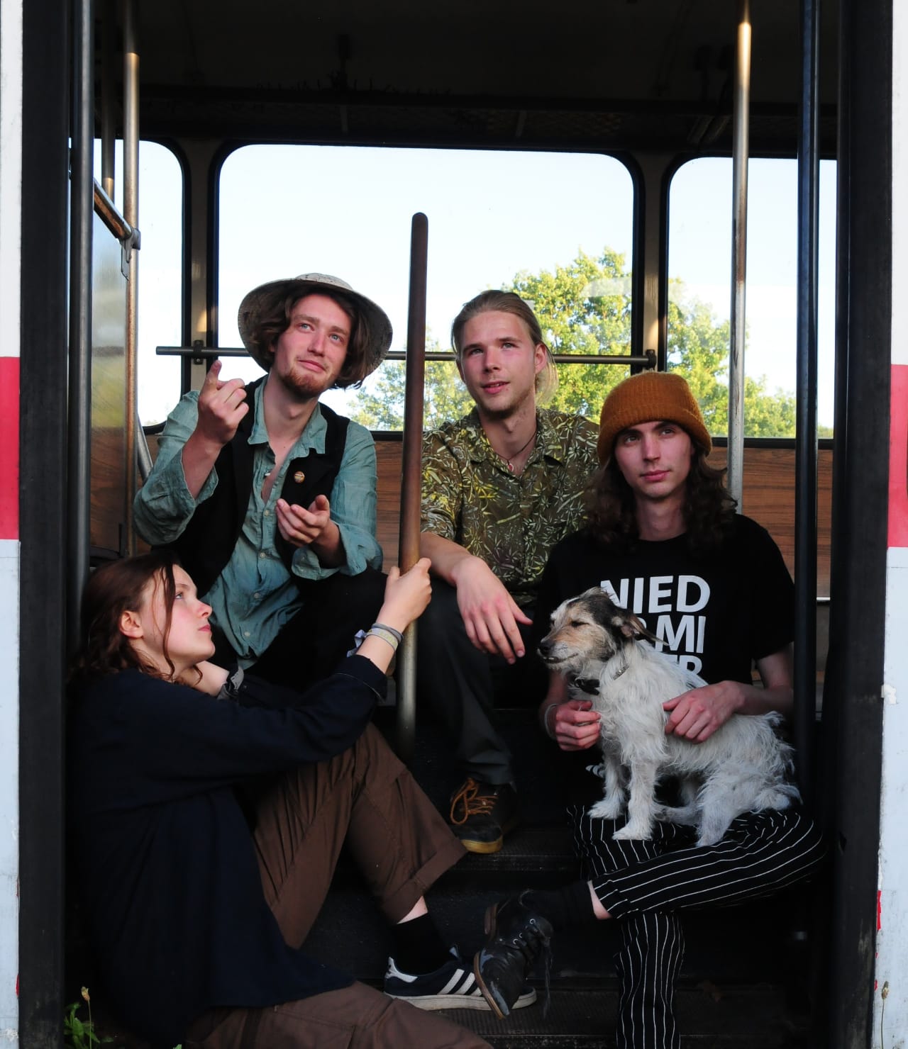 Foto von vier Menschen und einem Hund in einem Bus oder einer Straßenbahn