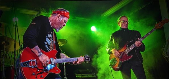 2 Gitarristen auf der Bühne, im Hintergrund