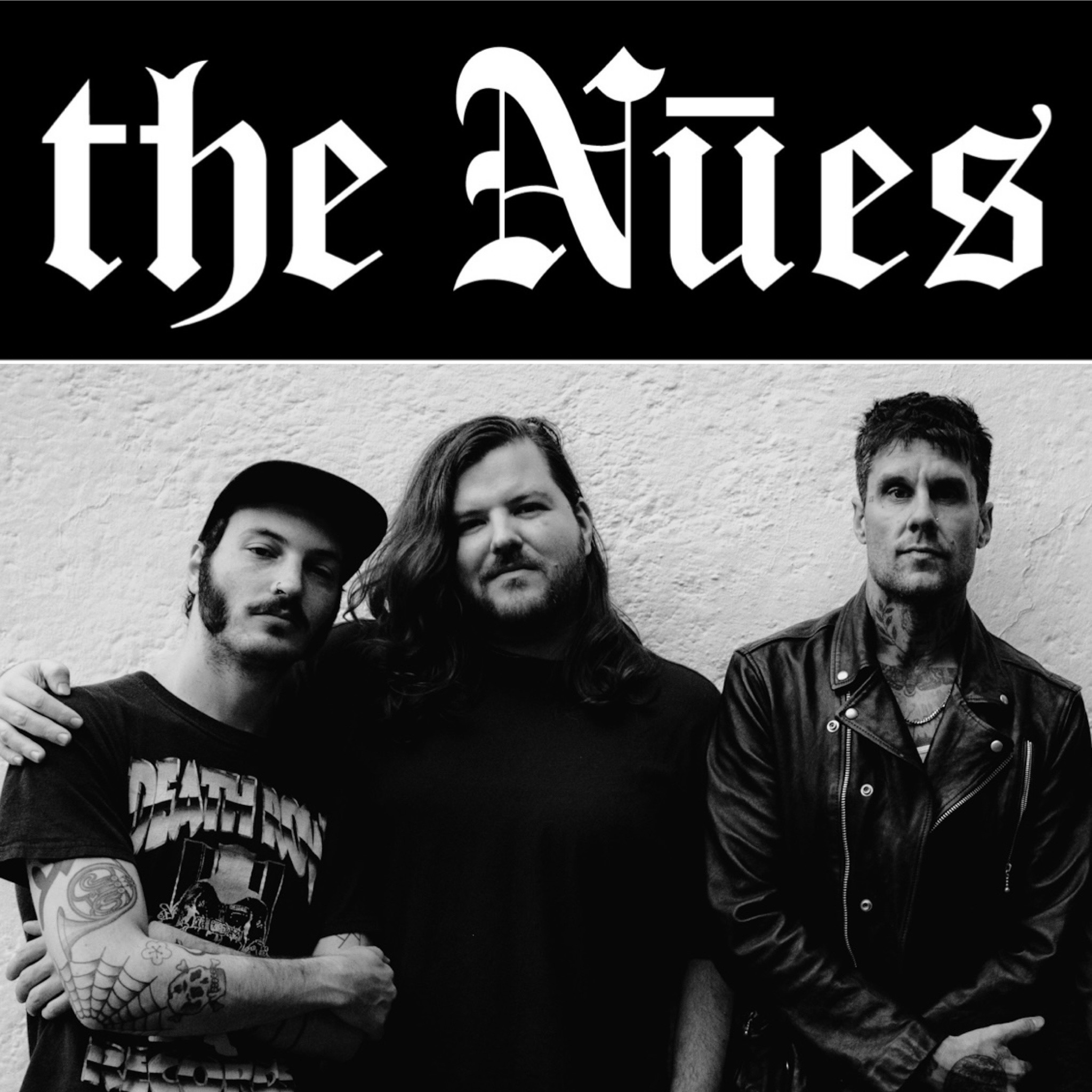 Schwarz weiß Foto von drei jungen Männer, alle in schwarz, darüber steht "the Nuez"