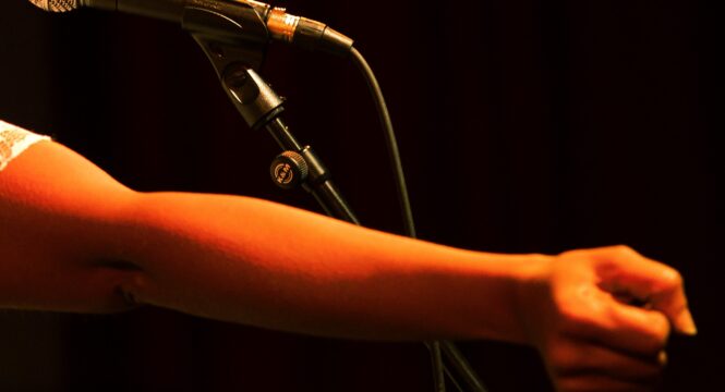 Buntfoto von einem Arm vor einem Mikrofon
