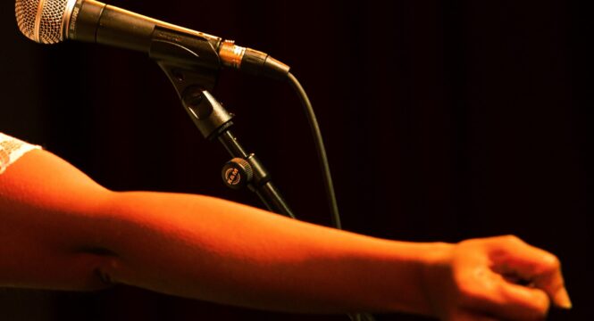 Buntfoto von einem Arm vor einem Mikrofon