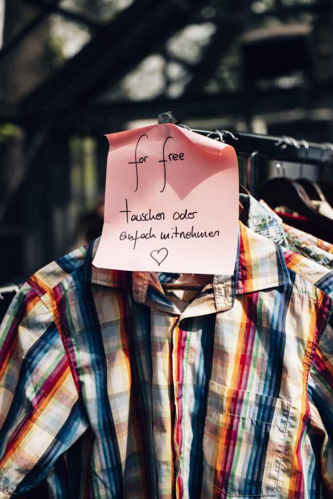 ein Kleiderständer mit Kleidung, daran ein Zettel mit der Aufschrift: for free, tauschen oder einfach mitnehmen