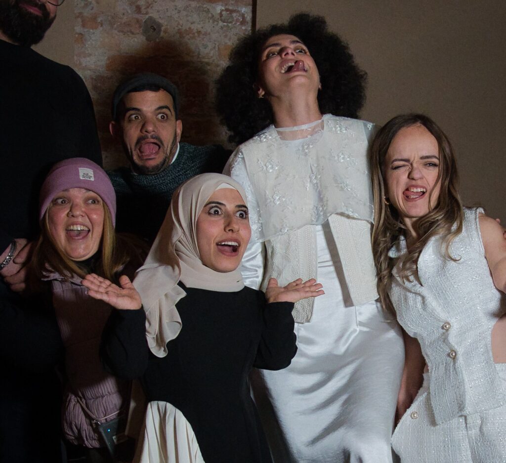 Models posen für die Kamera, einige strecken die Zunge heraus, andere blicken erschrocken