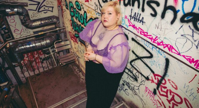Foto von einer Frau in einem Treppenhaus voller Graffiti,